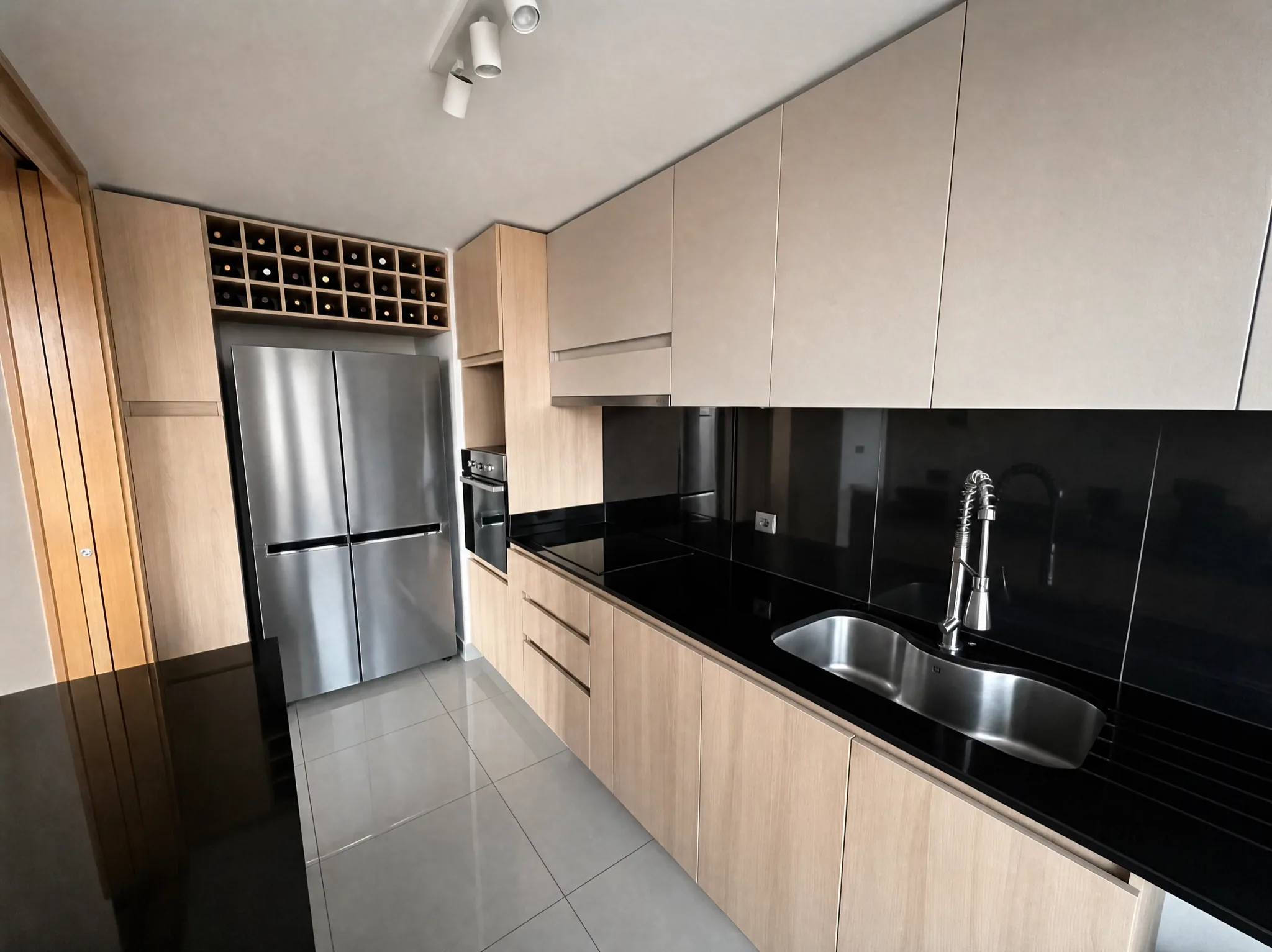 Cocina con refrigerador de dos puertas y cava de vinos empotrada