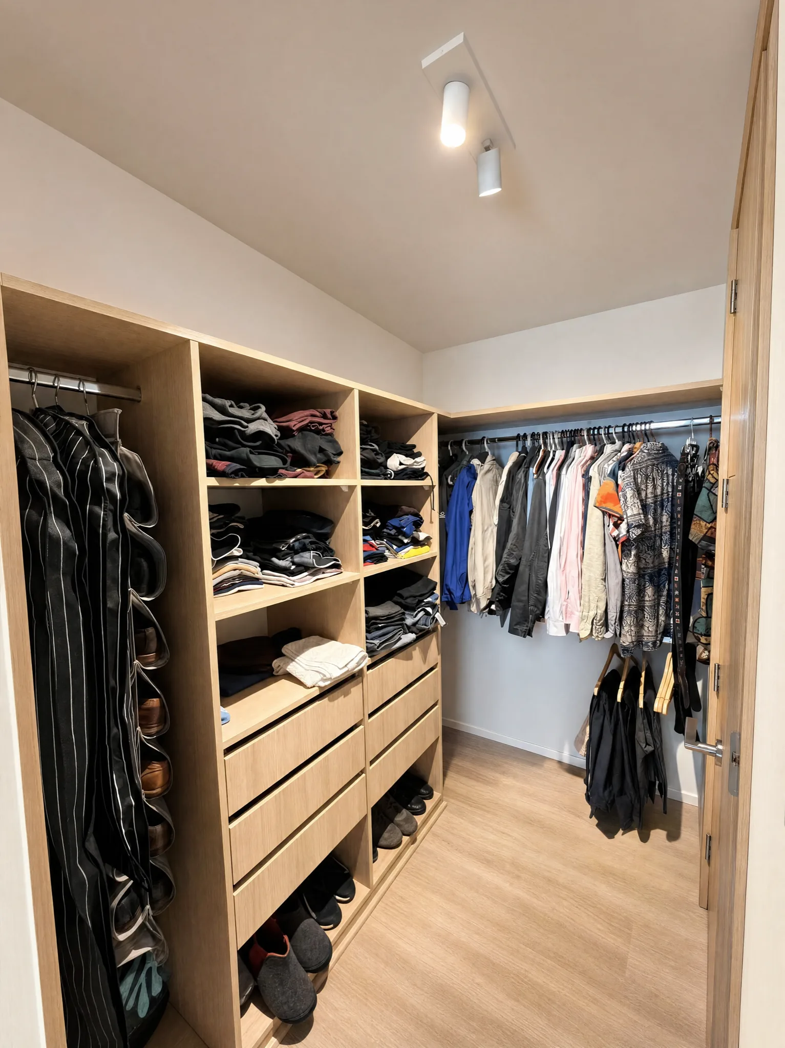 Vestidor con repisas, cajones y barras de colgado en madera clara