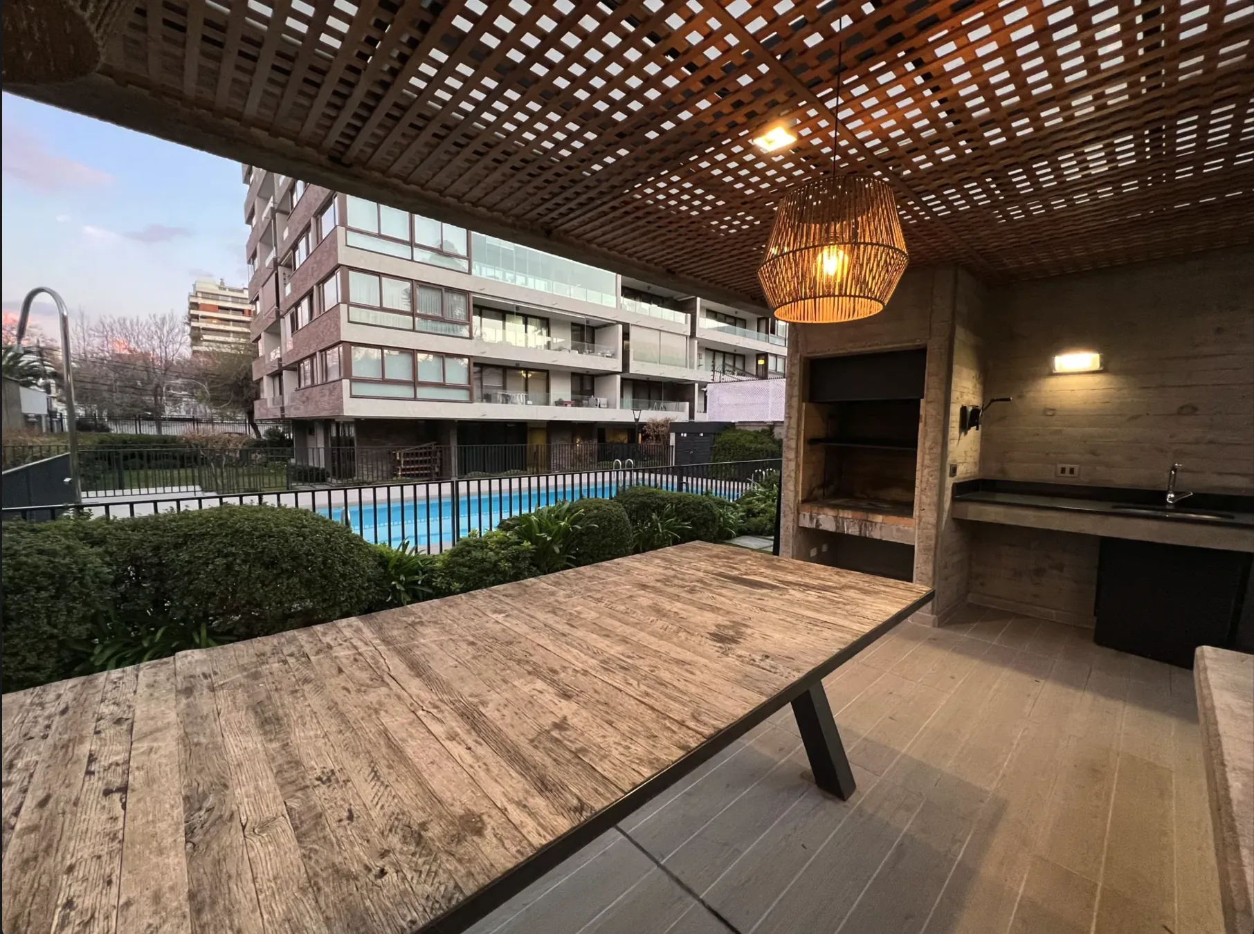 Quincho del edificio con parrilla y vista a la piscina
